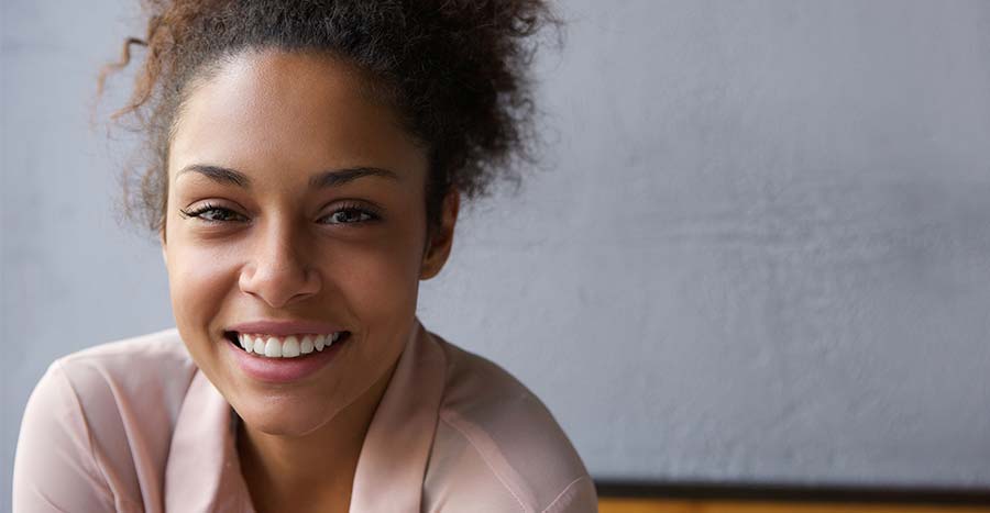 young-black-woman-with-frizzy-hair-and-a-bright-smile-is-looking-right-at-you