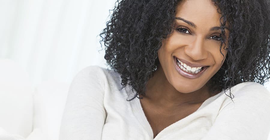 black-woman-with-dark-curly-hair-and-a-big-smile-is-looking-right-at-you